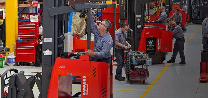 Raymond employees servicing forklifts