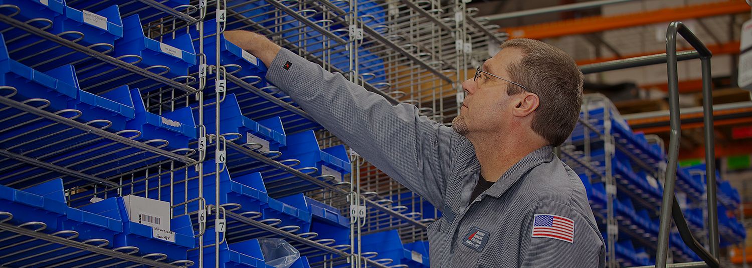 Man picking forklift parts from a rack