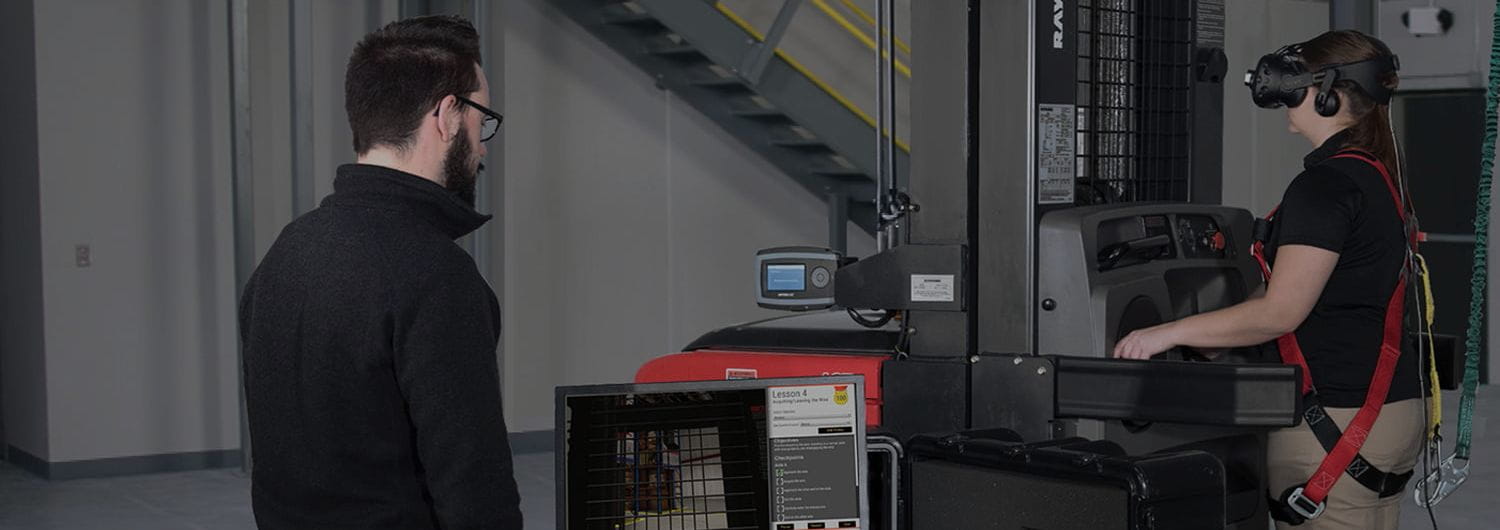 Man watching as woman uses VR for forklift training