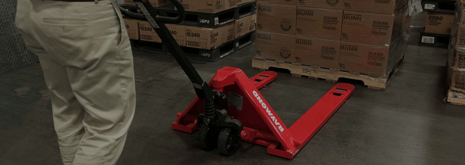Man operating a red Raymond hand pallet jack
