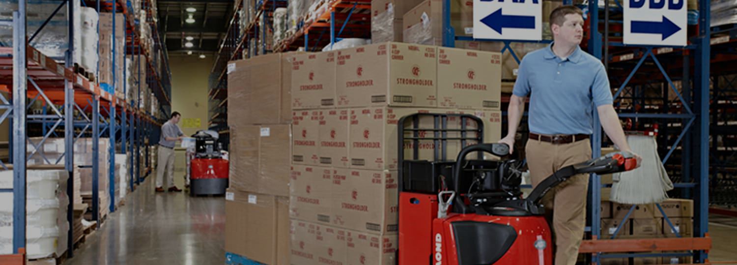 Man on electric pallet jack with load of boxes