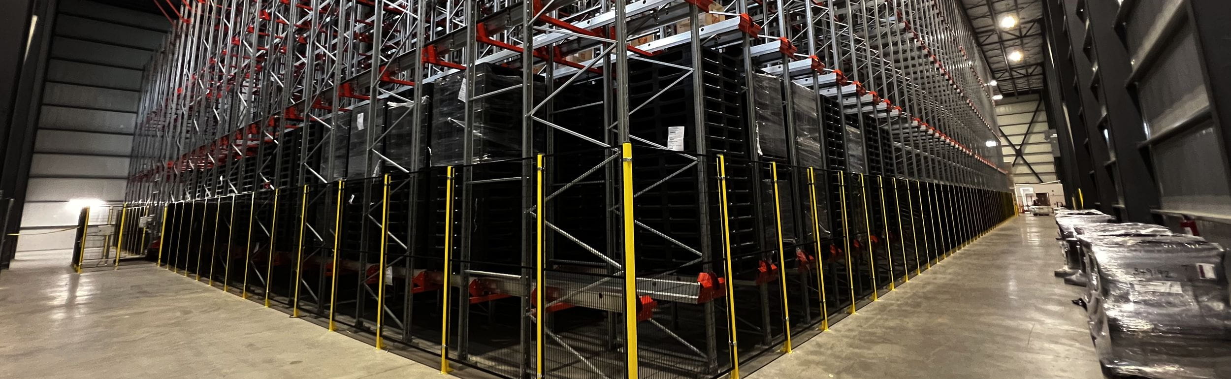 Yellow and black radioshuttle system around racking. Concept for Warehouse automation.