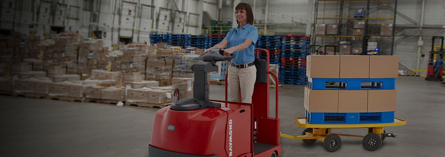Woman operating a tow tractor or tow tug forklift