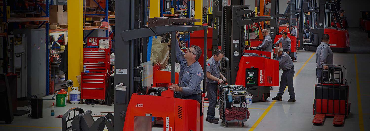 Red Raymond forklifts being cleaned and maintained. Concept for used forklifts.